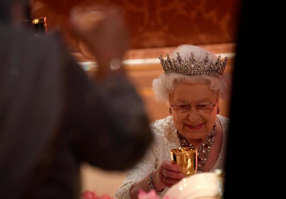 The Queen raises a glass during the speeches (REUTERS)