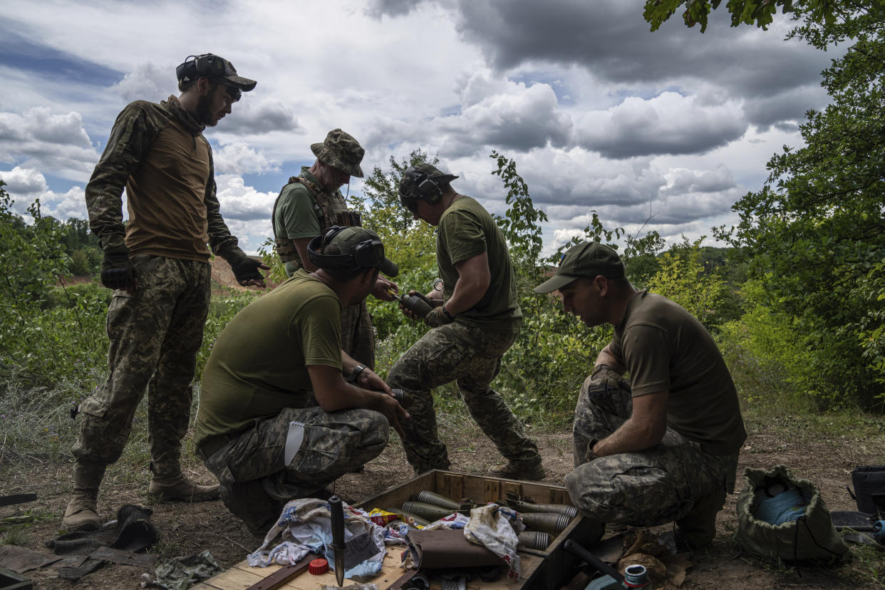 Ukrainian servicemen clean mortar shells during training in Kharkiv region, Ukraine, Tuesday, July 19, 2022. (AP Photo/Evgeniy Maloletka)