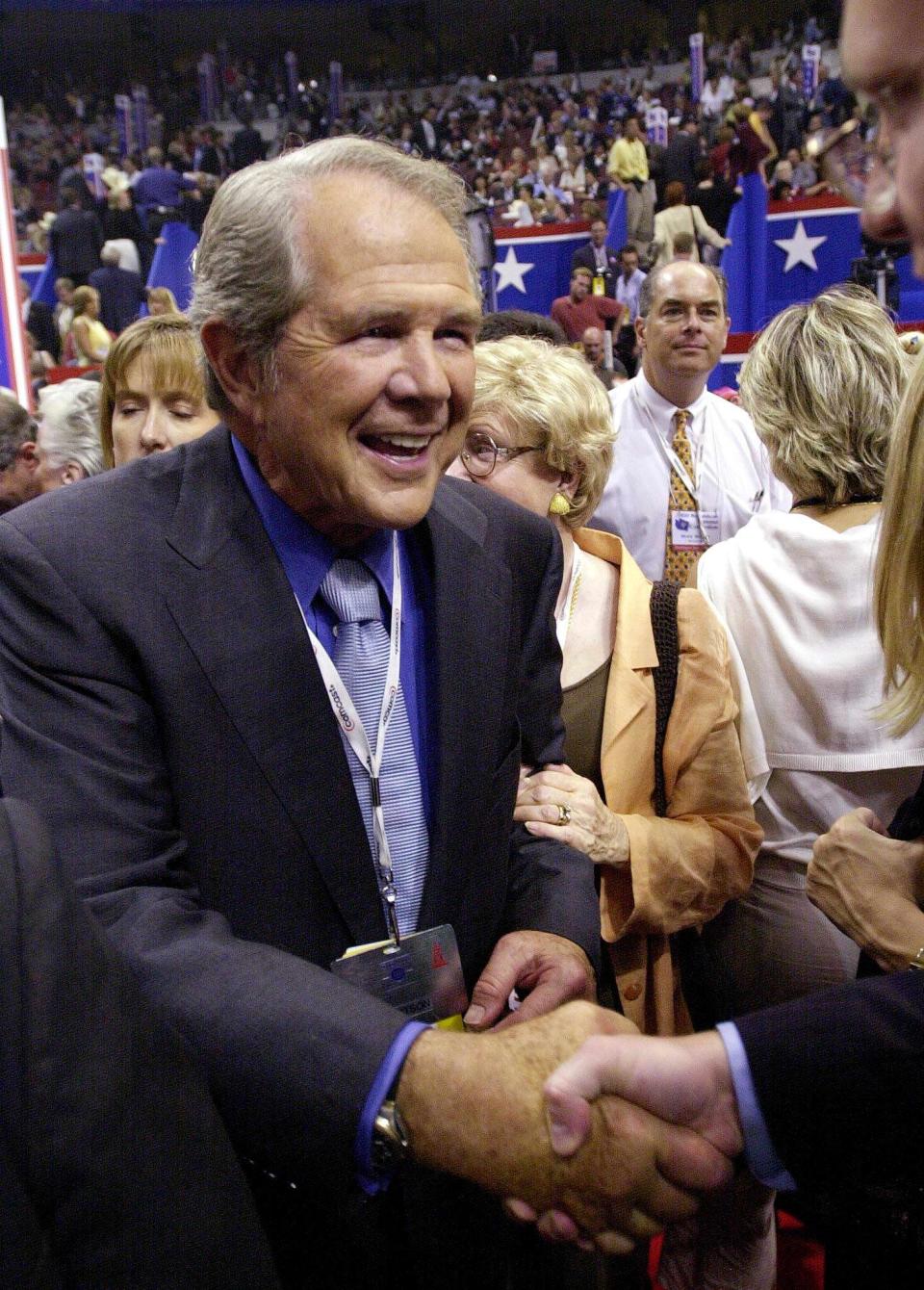 President of the Christian Coalition and former presidential candidate Pat Robertson shakes hands with supporters during the evening session of the 2000 Republican National Convention in Philadelphia's First Union Center on July 31, 2000.