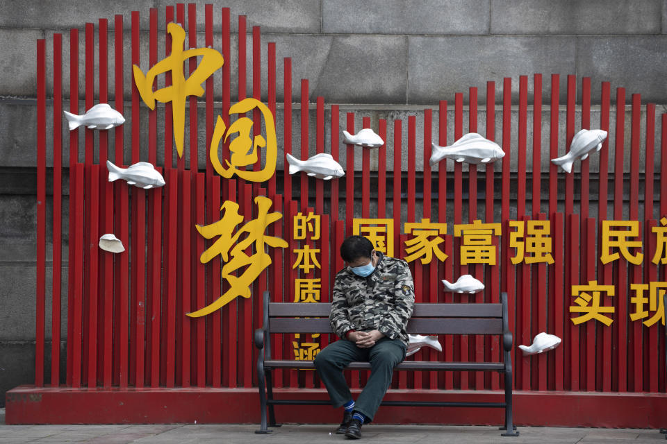 A resident naps near government propaganda which reads "China Dream" in Wuhan in central China's Wuhan province on Wednesday, April 1, 2020. Skepticism about China’s reported coronavirus cases and deaths has swirled throughout the crisis, fueled by official efforts to quash bad news in the early days and a general distrust of the government. In any country, getting a complete picture of the infections amid the fog of war is virtually impossible. (AP Photo/Ng Han Guan)