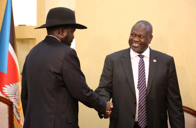 South Sudan's President Salva Kiir Mayardit shakes hands with Riek Machar, ex-vice president and former rebel leader, during their meeting at the State House in Juba