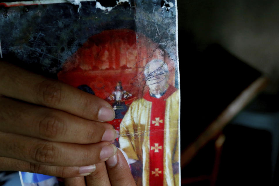 In this Jan. 25, 2019 photo, a resident holds an undated photograph of the town's Catholic parish priest Father Pius Hendricks, in Talustusan on Biliran Island in the central Philippines. (AP Photo/Bullit Marquez)