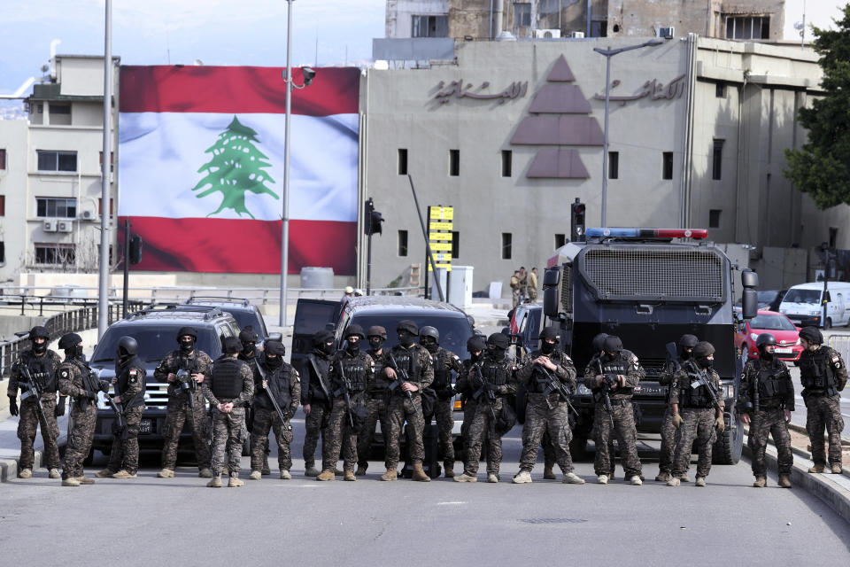 Special forces stand guard, as riot police scuffle with anti-government protesters near the parliament building in downtown Beirut, Lebanon, Monday, Jan. 27, 2020. Lebanese security forces clashed with protesters in downtown Beirut on Monday, leaving several demonstrators injured and others detained. As the protests simmered outside parliament, lawmakers held a controversial session to discuss and later approve the state budget amid a crippling financial crisis. (AP Photo/Bilal Hussein)