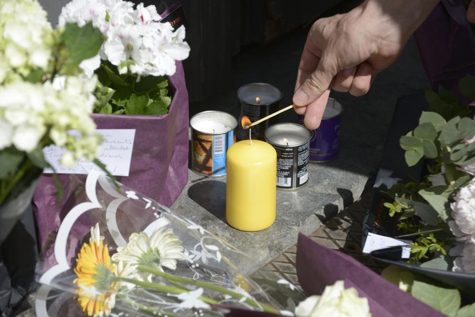 A passerby lights a candle at the entrance of the Jewish Museum, the site of a shooting incident, in central Brussels