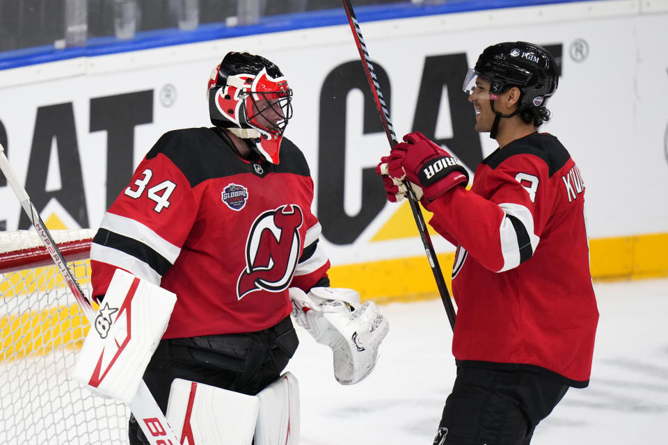 New Jersey Devils' Jake Allen, left, and New Jersey Devils' Johnathan Kovacevic ceelbrate after the NHL hockey game between Buffalo Sabres and New Jersey Devils, in Prague, Czech Republic, Saturday, Oct. 5, 2024. (AP Photo/Petr David Josek)