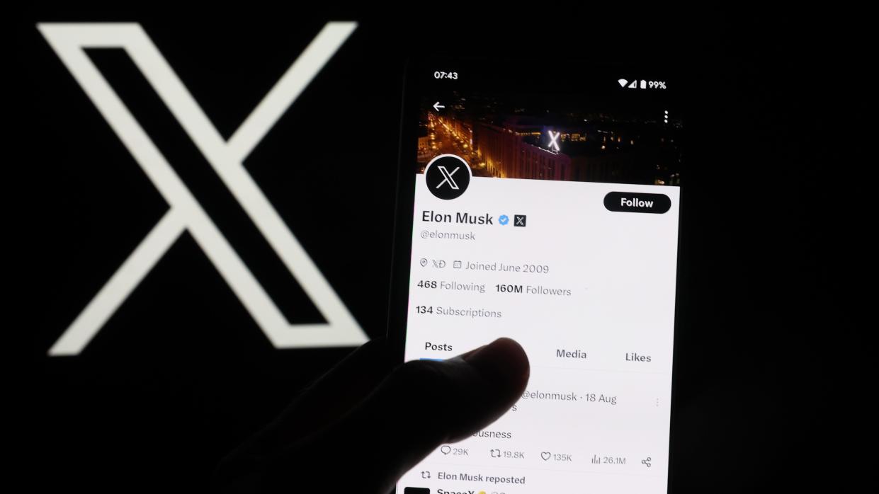 The X symbol next to a hand holding a phone with the X app on the screen