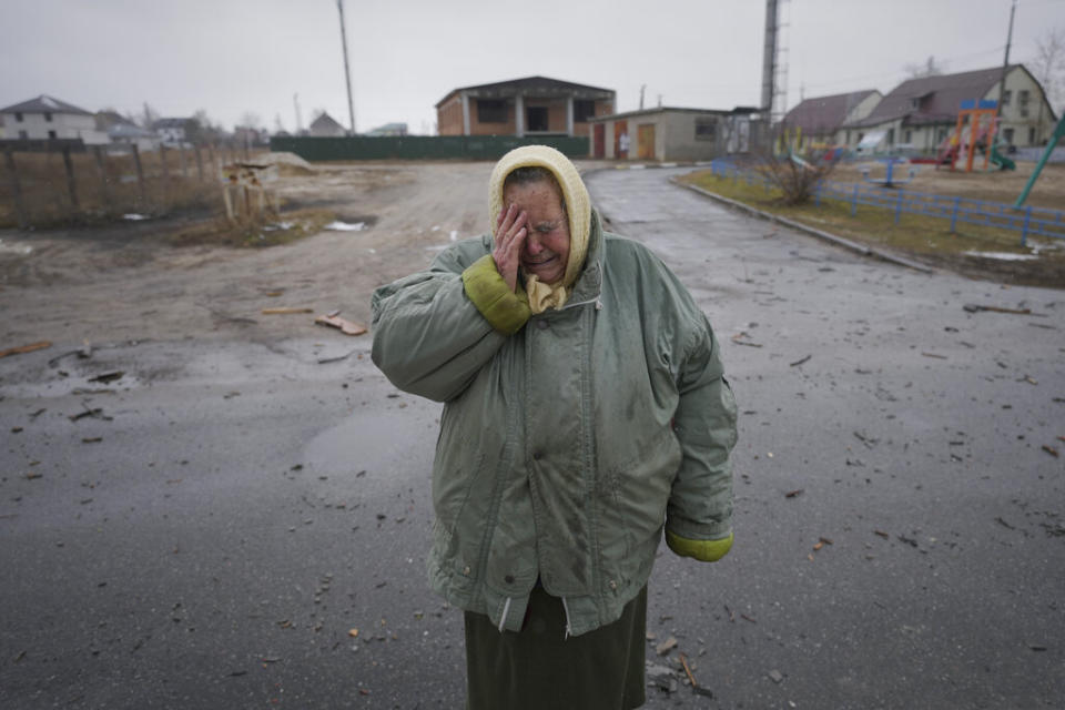 A woman cries outside houses damaged by a Russian airstrike, according to locals, in Gorenka, outside the capital Kyiv, Ukraine, Wednesday. Russia renewed its assault on Ukraine's second-largest city in a pounding that lit up the skyline with balls of fire over populated areas, even as both sides said they were ready to resume talks aimed at stopping the new devastating war in Europe. (AP Photo/Vadim Ghirda)