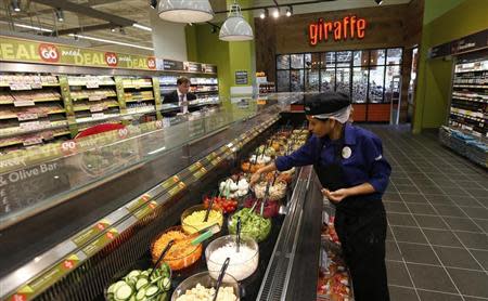 A Tesco employee prepares the salad bar outside the Giraffe restaurant at a Tesco Extra supermarket in Watford, north of London August 8, 2013. REUTERS/Suzanne Plunkett