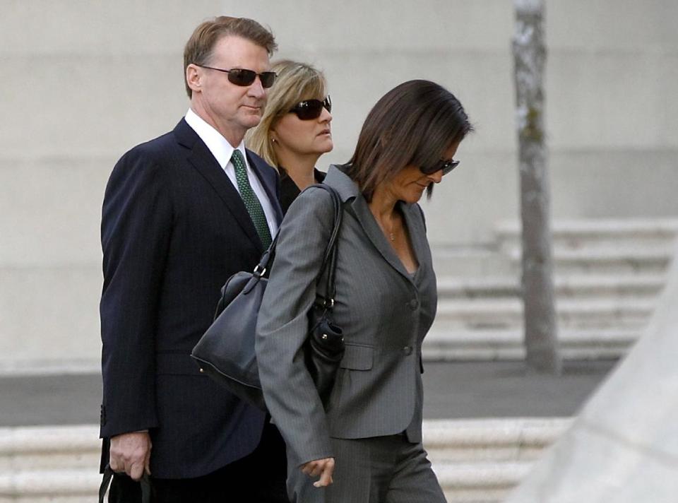 Former Deutsche Bank executive Brian Mulligan, left, arrives with his wife Victoria, center, at the Edward R. Roybal Federal Building, Tuesday, Jan. 21, 2014, in Los Angeles. A trial began for Mulligan, who sued the city of Los Angeles and two police officers claiming they beat him during a bizarre incident in May 2012. He is seeking $20 million in damages in a lawsuit filed in federal court. Officers said Mulligan told them he had ingested a type of bath salts known as White Lightning. Mulligan, who has no prior criminal record, once served as co-chairman of Universal Studios and chief financial officer of Seagram Co. (AP Photo/Damian Dovarganes)