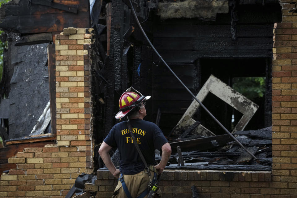 Houston Fire Department Senior Captain Chris Delbello surveys a damaged home after a fire Tuesday, May 28, 2024, in the Third Ward neighborhood in Houston. Neighbors said the house caught fire as a storm moved through the area. (Jon Shapley/Houston Chronicle via AP)