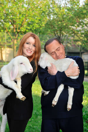 Former prime minister Silvio Berlusconi (R) holds and hugs a lamb as he poses with Michela Vittoria Brambilla, animal right activist and member of parliament for Berlusconi's Forza Italia party, in this undated photo released by the Italian League in Defence of Animals and the Environment. Maurizio Calzari/Lega Italiana Difesa Animali e Ambiente/Handout via Reuters