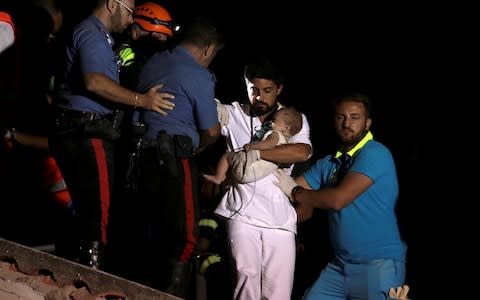 A doctor carries a child after an earthquake hits the island of Ischia, off the coast of Naples - Credit: REUTERS