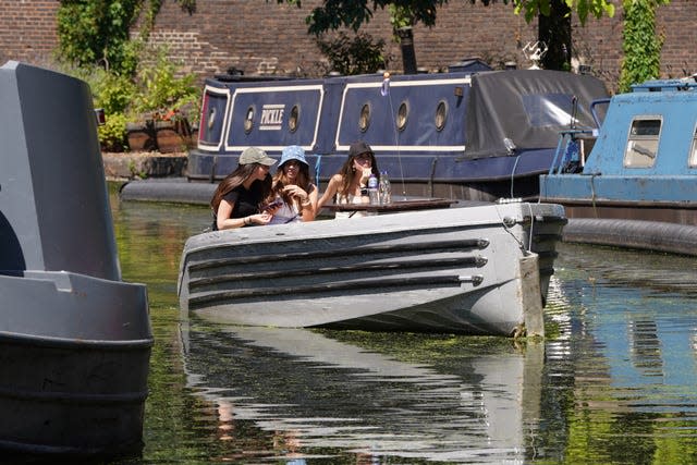 People enjoy a boat ride on the canal in Paddington Basin, London, as the heatwave continues in the UK