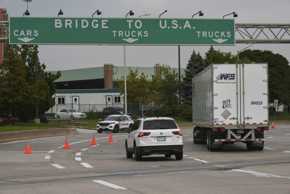 FILE - In this Oct. 4, 2021, file photo, traffic moves towards a police car by the Ambassador Bridge border crossing in Windsor, Ontario, Canada. The Biden administration's decision to allow nonessential travel by vaccinated people to enter the U.S. by land starting Nov. 8 has many Canadians packing up their campers and making reservations at their favorite vacation condos and mobile home parks in warmer climes like Arizona, Florida and even Mexico. (Rob Gurdebeke/The Canadian Press via AP, File)