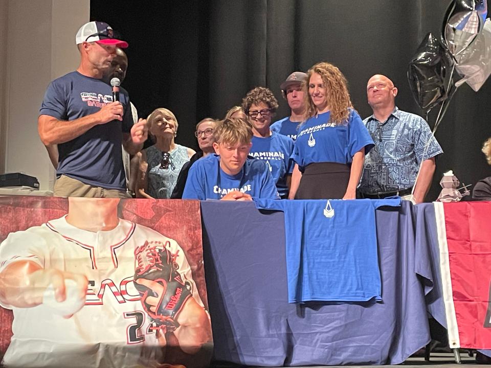 Baseball player Cooper Houvouras, seated and joined by family, is addressed by his coach before signing with Chaminade on May 8, 2024.