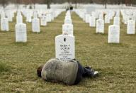 RNPS - PICTURES OF THE YEAR 2013 - Lesleigh Coyer, 25, of Saginaw, Michigan, lies down in front of the grave of her brother, Ryan Coyer, who served with the U.S. Army in both Iraq and Afghanistan, at Arlington National Cemetery in Virginia March 11, 2013. Coyer died of complications from an injury sustained in Afghanistan. REUTERS/Kevin Lamarque (UNITED STATES - Tags: CONFLICT OBITUARY TPX MILITARY)