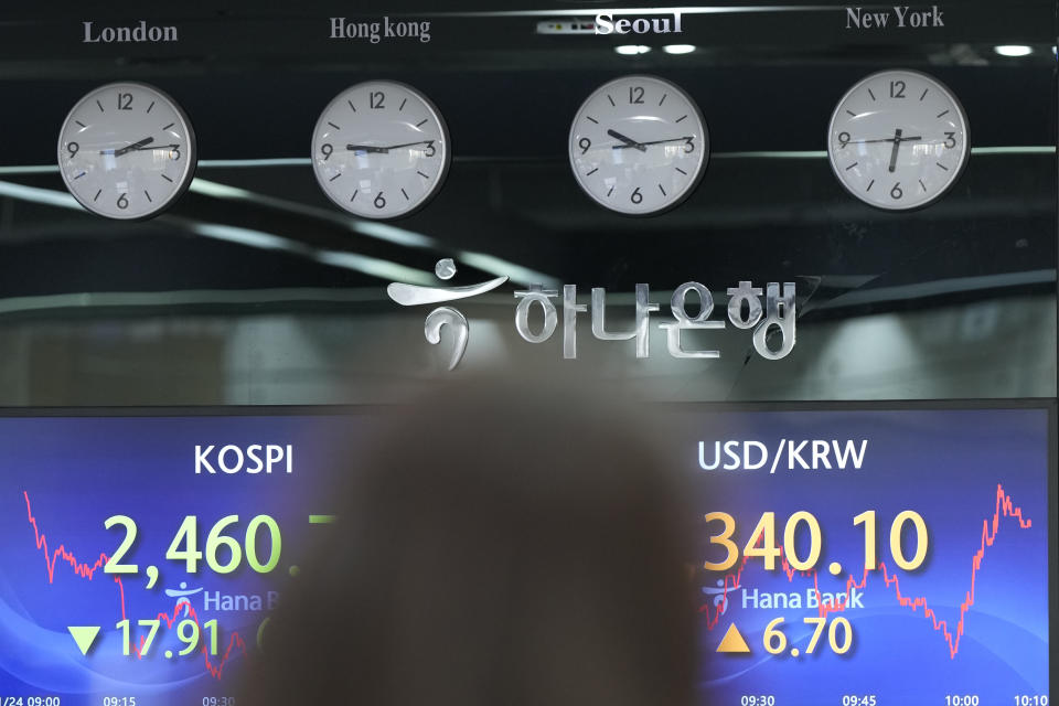 A currency trader walks by the screens showing the Korea Composite Stock Price Index (KOSPI), left, and the foreign exchange rate between U.S. dollar and South Korean won at a foreign exchange dealing room in Seoul, South Korea, Wednesday, Jan. 24, 2024. Asian shares are mixed after Japan reported its exports jumped nearly 10% in December over a year earlier. But shares in Tokyo fell nearly 1% after a recent strong rally as speculation revived over a shift away from longstanding lax monetary policy by the Bank of Japan. (AP Photo/Lee Jin-man)