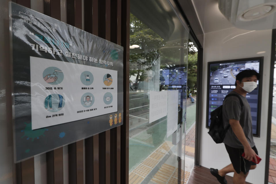 A poster on precautions against the coronavirus is displayed inside a bus shelter designed to block people with fever amid a spread of the coronavirus, at a bus stop in Seoul, South Korea, Friday, Aug. 14, 2020. The glass panels-covered bus stops at a Seoul district, are equipped with thermal cameras that screen people for fevers and also automatic doors that doesn’t let in any one with high temperatures. The sign reads "Prevention rules to remember and practice." (AP Photo/Ahn Young-joon)