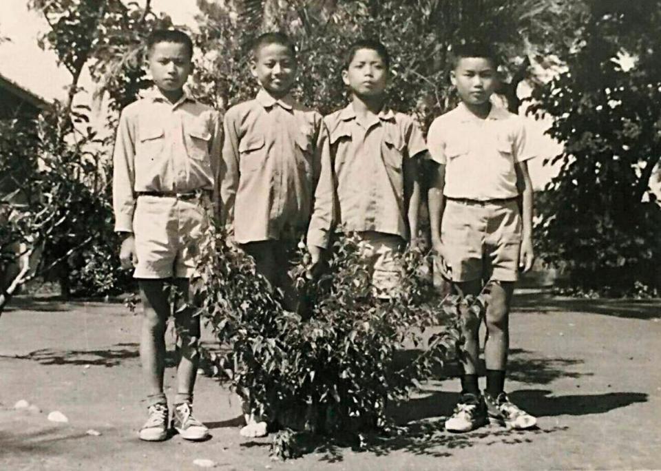 許倉賓（左2）自幼家貧，小時候沒錢買鞋，拍照時還把腳藏在樹叢後方。（許倉賓提供）