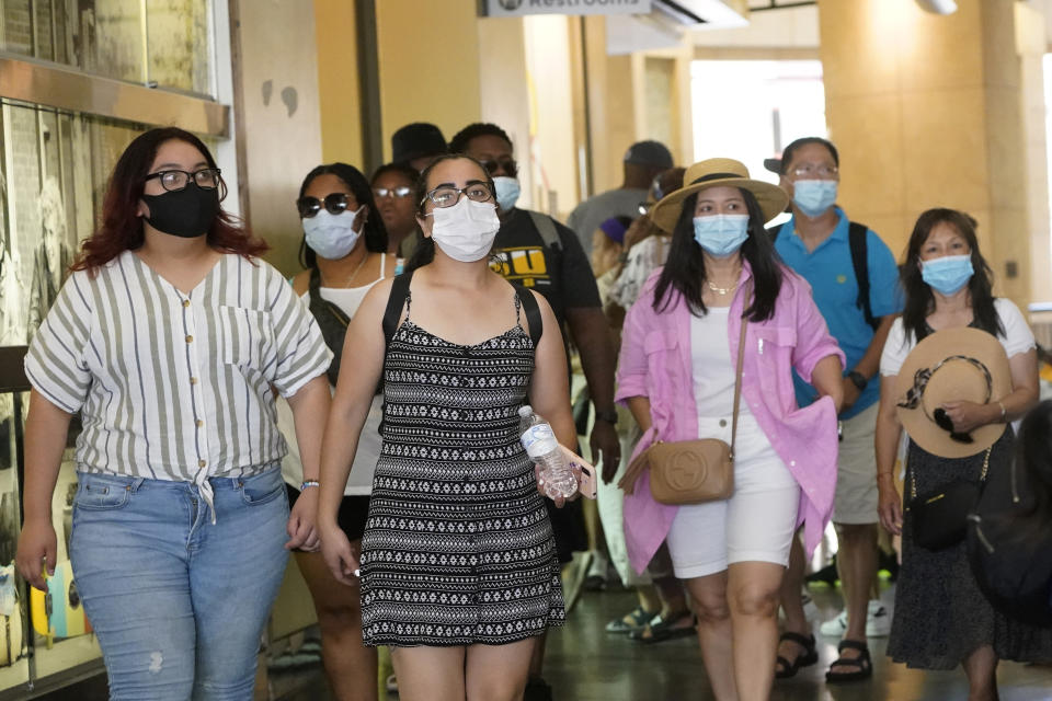 FILE - In this July 1, 2021, file photo visitors wear masks as they walk in a shopping district in the Hollywood section of Los Angeles. A rapid and sustained increase in COVID-19 cases in the nation's largest county requires restoring an indoor mask mandate even when people are vaccinated, Los Angeles County's public health officer said Thursday, July 15, 2021. (AP Photo/Marcio Jose Sanchez, File)