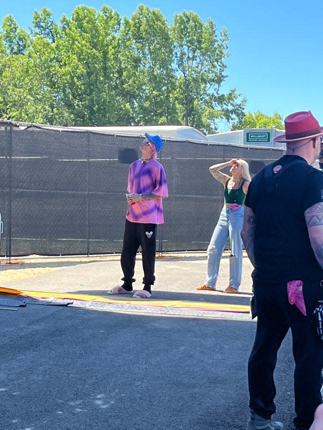 Machine Gun Kelly catches a set by The Aces on Bonnaroo's What Stage Sunday, June 19, 2022.  He will be performing on the same stage later.