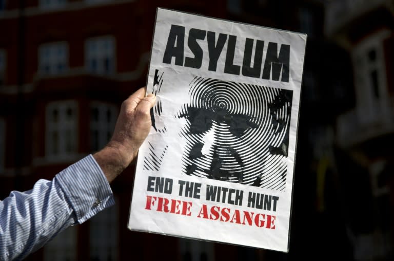 A supporter of Julian Assange holds a banner he marks three years since the Wikileaks founder claimed asylum inside the Ecuadorian embassy in London, on June 19, 2015