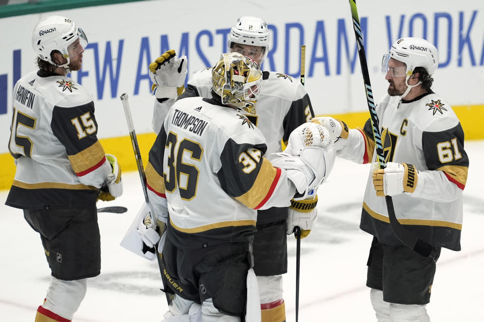 Vegas Golden Knights goaltender Logan Thompson (36) celebrates with Mark Stone (61), Noah Hanifin (15) and Zach Whitecloud (2) after Game 1 of an NHL hockey Stanley Cup first-round playoff series against the Dallas Stars in Dallas, Monday, April 22, 2024. The Golden Knights won 4-3. (AP Photo/Tony Gutierrez)
