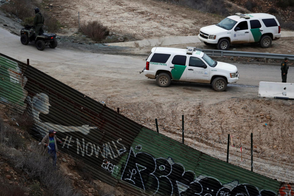 A migrant walks away after seeing U.S. CBP officials