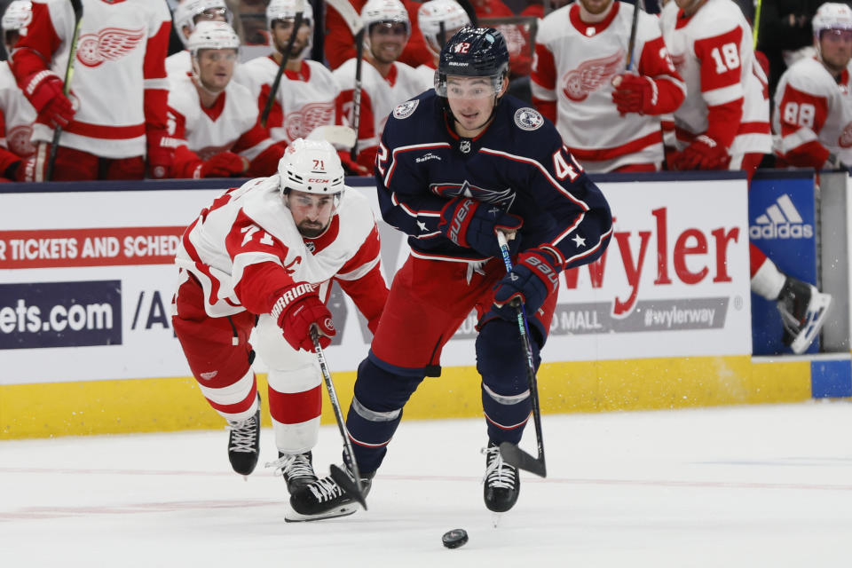 Detroit Red Wings' Dylan Larkin, left, tries to knock the puck away from Columbus Blue Jackets' Alexandre Texier during the second period of an NHL hockey game Monday, Oct. 16, 2023, in Columbus, Ohio. (AP Photo/Jay LaPrete)