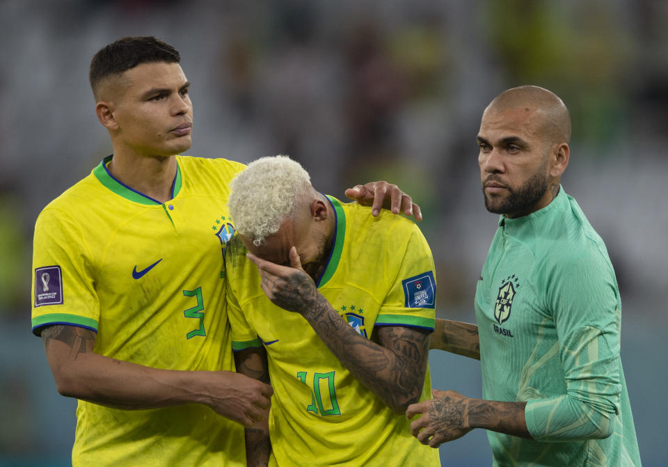 AL RAYYAN, QATAR - DECEMBER 09: Neymar of Brazil is consoled by team mates Thiago Silva and Dani Alves during the FIFA World Cup Qatar 2022 quarter final match between Croatia and Brazil at Education City Stadium on December 9, 2022 in Al Rayyan, Qatar. (Photo by Visionhaus/Getty Images)