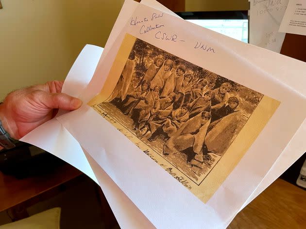 A copy of a 19th-century photograph, showing pupils at an Indigenous boarding school in Santa Fe, is held by researcher Larry Larrichio during an interview in Albuquerque, New Mexico, on July 8, 2021.