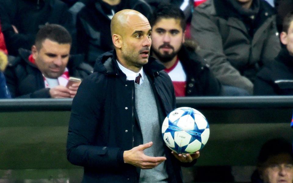 Pep Guardiola holds ball white wearing jumper - EPA