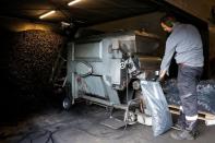 Coal seller Gerben van Beek fills a bag with coal, in Veenendaal