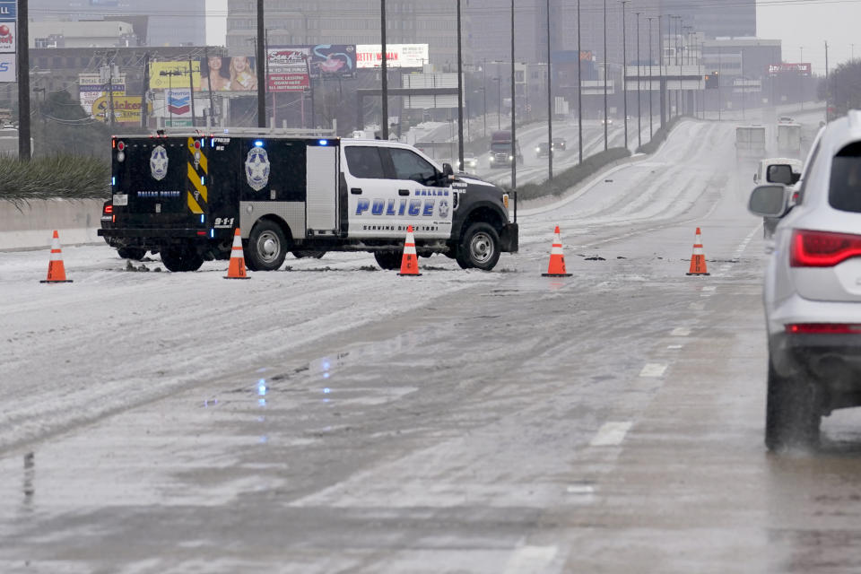 A City of Dallas emergency vehicle blocks lanes of U.S. Highway 75 during icy and slushy road conditions, Wednesday, Feb. 1, 2023, in Dallas. (AP Photo/Tony Gutierrez)