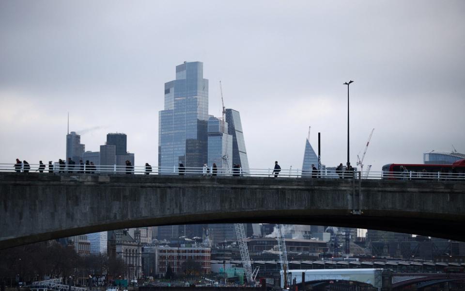 People walk across Waterloo Bridge during morning rush hour, with the City of London financial district in the background, in London, Britain, January 26, 2023. REUTERS/Henry Nicholls - HENRY NICHOLLS/REUTERS