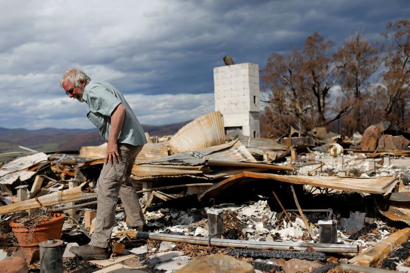 Donald Graham, 68, looks through the remains of his home which was destroyed by bushfires in Buchan, Victoria, Australia
