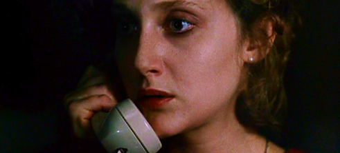 A woman answers the phone, looking terrified