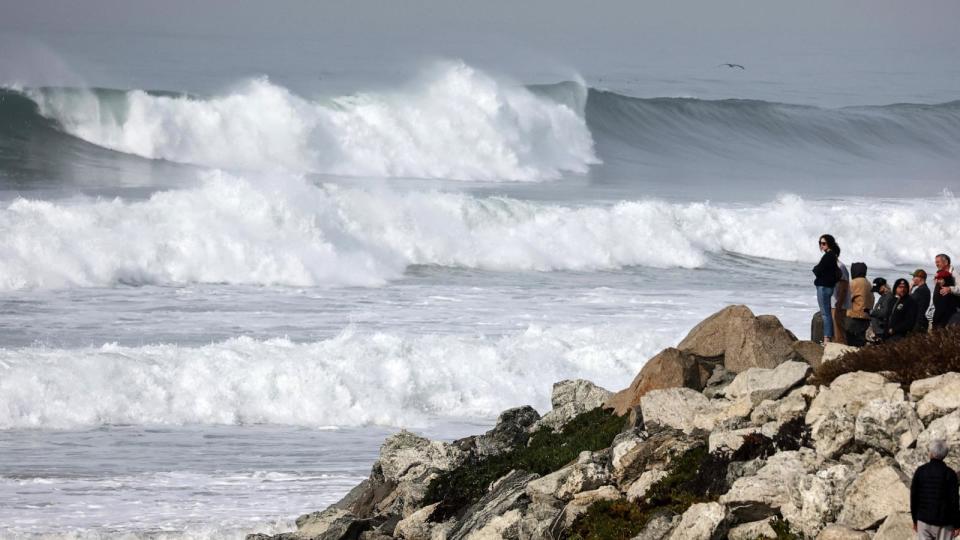PHOTO: Onlookers watch as large waves break near the beach on Dec. 29, 2023, in Manhattan Beach, Calif. (Mario Tama/Getty Images)