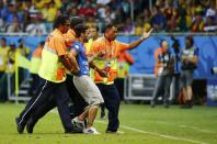 A pitch invader is escorted away by stewards during the 2014 World Cup round of 16 game between Belgium and the U.S. at the Fonte Nova arena in Salvador July 1, 2014. REUTERS/Yves Herman (BRAZIL - Tags: SOCCER SPORT WORLD CUP)