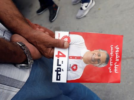 A supporter of presidential candidate Nabil Karoui holds a leaflet during a campaign in Tunis