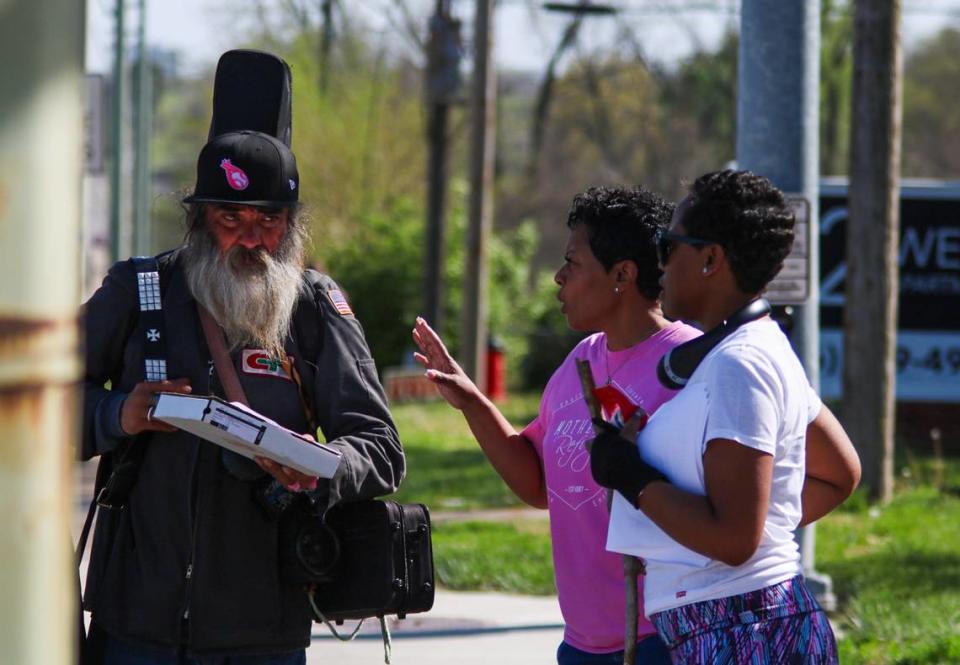 Eraina Buie and her daughter Denisha Jones hand a flyer to a man walking on Troost Avenue. The mother-daughter team have helped in the effort to find T’Montez Hurt, who went missing in Kansas City Feb. 1.