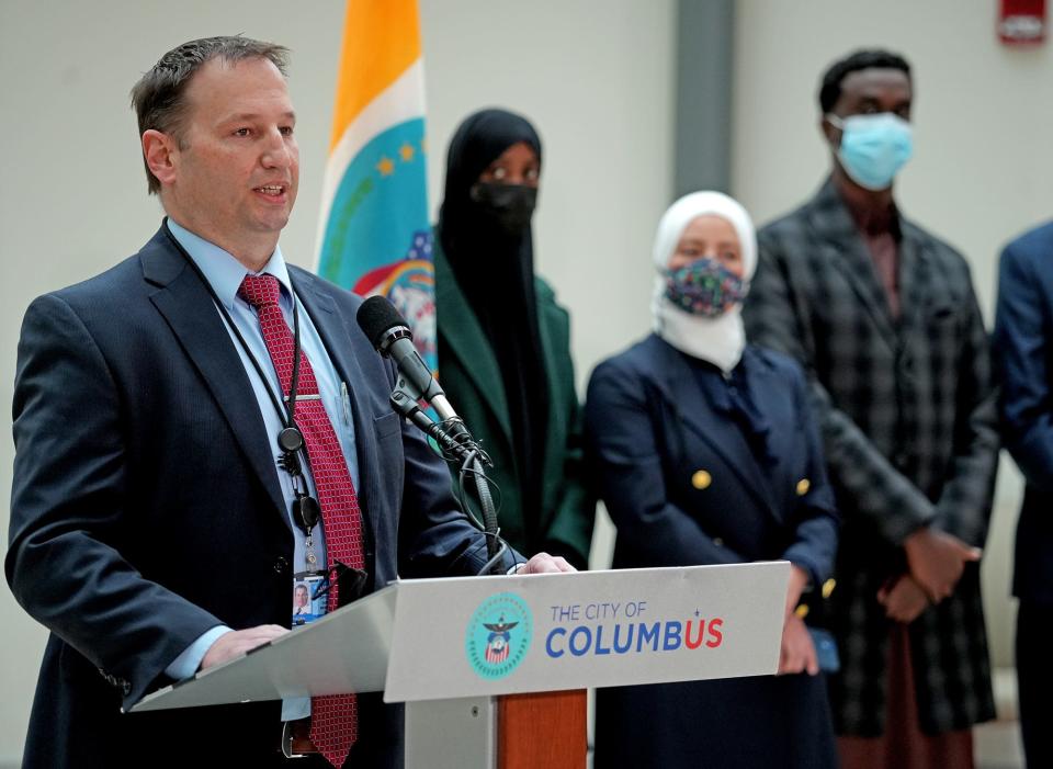 Columbus police detective Earl Westfall, at left, speaks Friday at a news conference at City Hall, where police formally announced that a suspect had been arrested in the murder of Mohamed Hassan Adam.