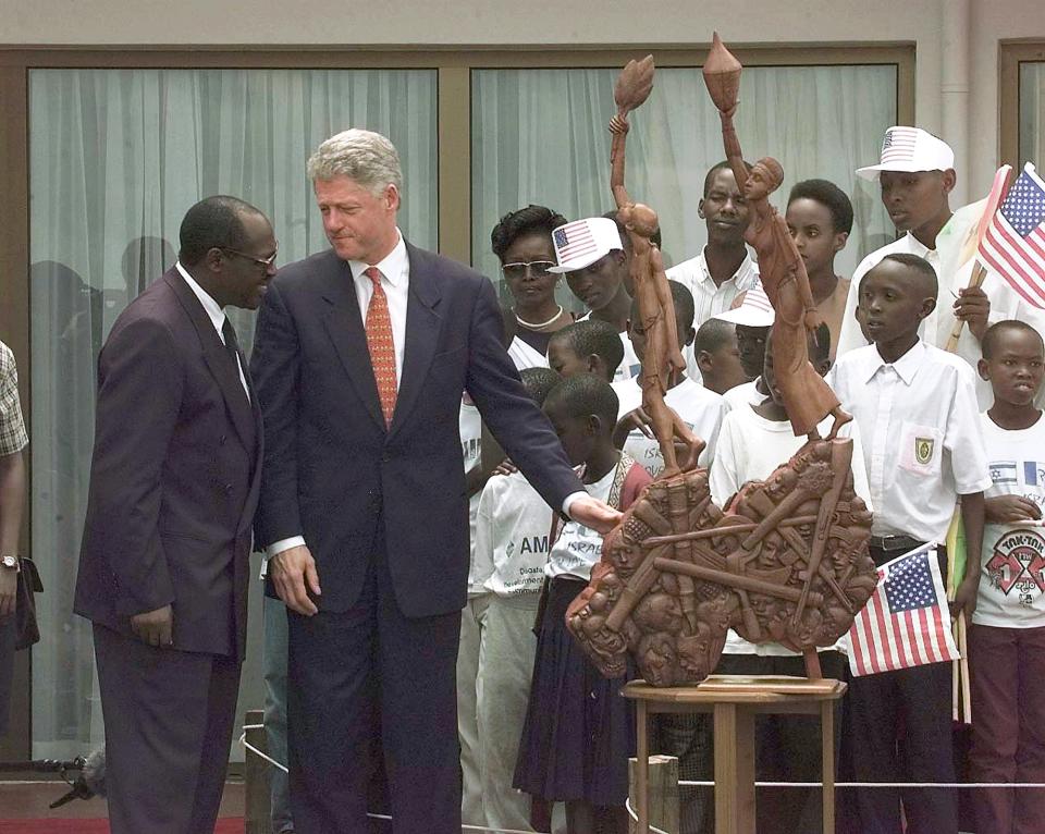 President Bill Clinton touches a statue commemorating the 1994 genocide in Rwanda, presented to him by Rwanda's President Pasteur Bizimingu, on March 25, 1998. (Photo: J. Scott Applewhite/AP)