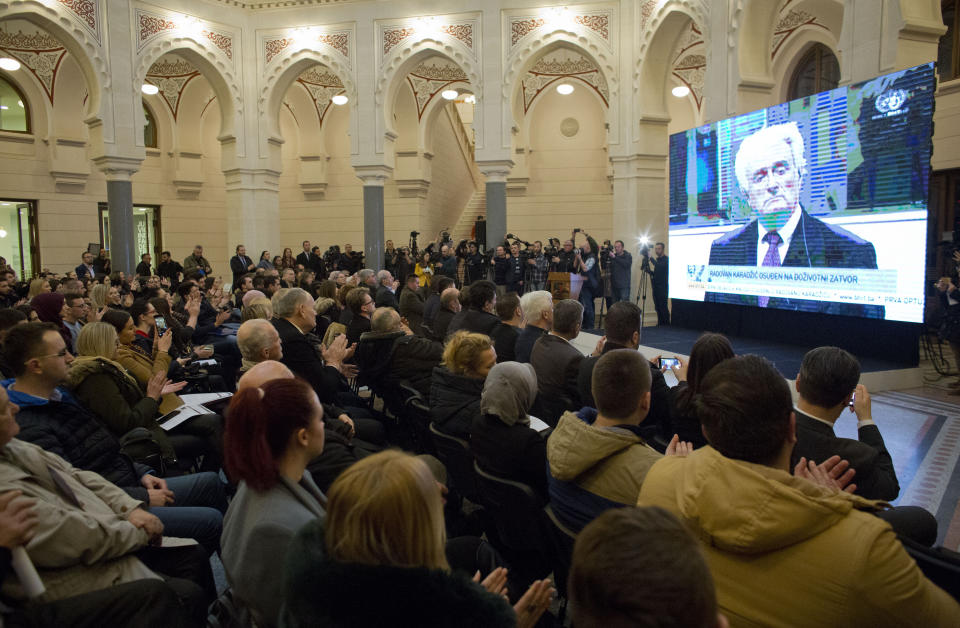 The crowd applaudes as U.N. court's conviction and sentencing of ex-Bosnian Serb leader Radovan Karadzic is broadcasted in the city hall in Sarajevo, Bosnia-Herzegovina, Wednesday, March 20, 2019. United Nations appeals judges have upheld the convictions of former Bosnian Serb leader Radovan Karadzic for genocide, war crimes and crimes against humanity and increased his sentence from 40 years to life imprisonment. (AP Photo/Darko Bandic)