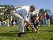 <p>President Barack Obama helps a little boy roll his egg to the finish line during the annual White House Easter Egg Roll, Monday, April 9, 2012, on the South Lawn of the White House in Washington. In the background, at left are Malia Obama and Sasha Obama. (Photo: Carolyn Kaster/AP) </p>