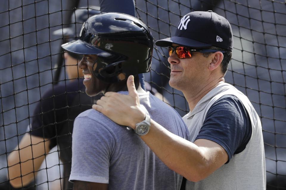 New York Yankees manager Aaron Boone, right, talks to Cameron Maybin, left, during a baseball team workout Wednesday, Oct. 2, 2019, at Yankee Stadium in New York. Yankees will host the Minnesota Twins in the first game of an American League Division Series on Friday. (AP Photo/Frank Franklin II)