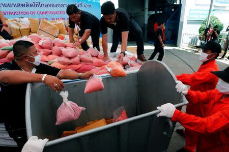 Thai narcotics officials put bags of methamphetamine pills into a bin during the 47th Destruction of Confiscated Narcotics ceremony in Ayutthaya province, north of Bangkok, Thailand June 26, 2017. REUTERS/Chaiwat Subprasom