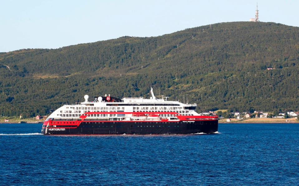 The expedition cruise ship Roald Amundsen leaves harbour in Tromso's city center and is heading towards Breivika harbour north of the city, on August 2, 2020. - At least 36 crew members and three passengers onboard the ship owned by the Norwegian company Hurtigruten, a specialist in expedition cruises, have so far tested positive for the new coronavirus.