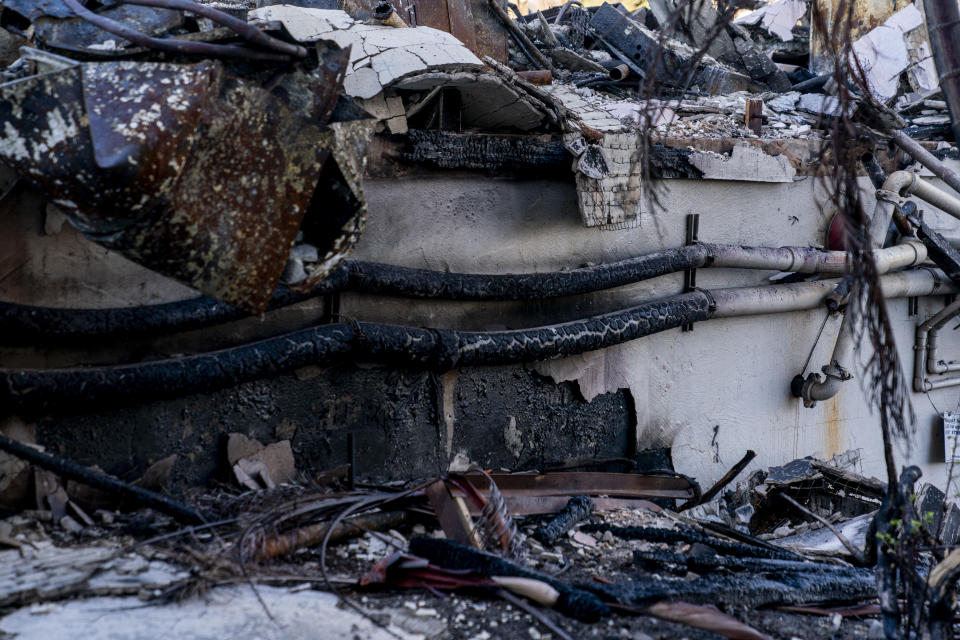 Charred pipes and debris are seen in a destroyed business complex next to the Lahaina Shores Beach Resort on Front Street, Friday, Dec. 8, 2023, in Lahaina, Hawaii. Resident Janet Spreiter, who lived across the street, and other residents say they have concerns about the water with wildfire debris and toxins potentially seeping into the ocean or being pumped uphill to a tank that could seep into groundwater. (AP Photo/Lindsey Wasson)