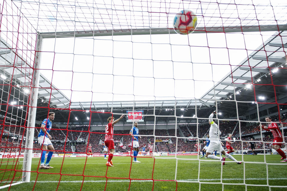 Freiburg's Maximilian Eggestein, second right, scores the goal to make it 1-0 against Hoffenheim goalkeeper Oliver Baumann during the German Bundesliga soccer match between TSG 1899 Hoffenheim and SC Freiburg in Freiburg im Breisgau, Germany, Sunday March 12, 2023. (Tom Weller/dpa via AP)